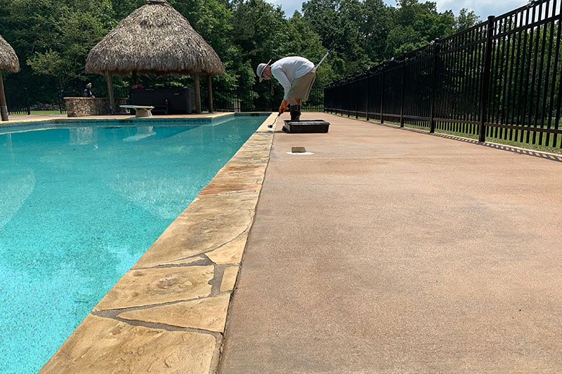 person doing concrete work next to pool